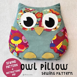 Könnte beinhalten: Ein teal-farbenes, eulenformiges Kissen mit großen weißen Augen und schwarzen Pupillen. Die Flügel und Augen der Eule sind mit bunten Blumenmustern verziert. Der Text "owl pillow sewing pattern" ist in Schwarz dargestellt, mit einem rosa Kreis mit "sewing pattern + instructions pdf".