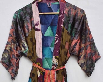 May include: A long, patchwork kimono robe with a variety of floral and geometric patterns in shades of green, purple, pink, and blue. The robe has wide sleeves and a matching belt. The text "OLD MARKET SHOP" is visible on the lower right.