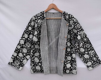 Könnte beinhalten: Schwarze und weiße gesteppte Jacke mit Blumendruck und gestreiftem Futter. Die Jacke hat einen Knopfverschluss und lange Ärmel.