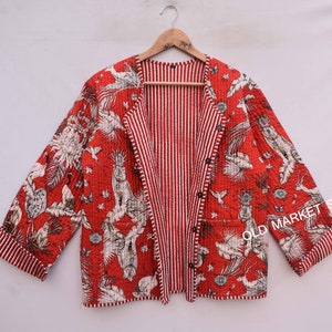 Peut inclure: Une veste matelassée rouge et blanche avec un imprimé floral et une doublure rayée. La veste a une fermeture boutonnée et est en coton.
