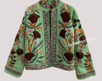 May include: A mint green embroidered jacket with floral patterns in shades of pink, orange, brown, and black. The jacket has a mandarin collar and a front closure.