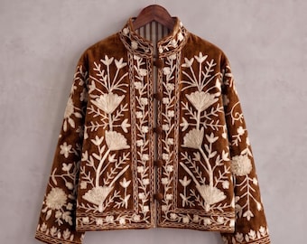 May include: A brown velvet jacket featuring cream-colored floral embroidery throughout the front and sleeves. The jacket has a high collar, long sleeves, and a front closure secured by four round brown fabric-covered buttons on a vertical placket.