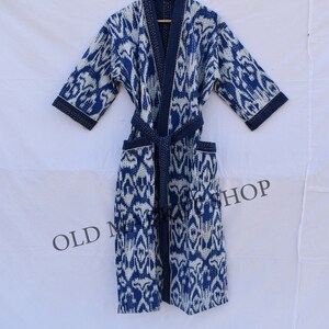 May include: A blue and white patterned robe with a tie belt. The robe is made of cotton and has a quilted design.