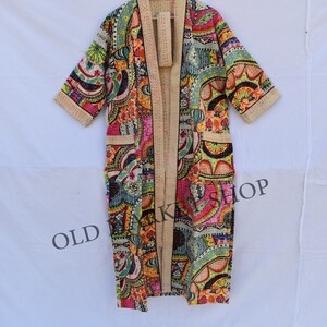 May include: A long, colorful, patterned robe with a cream-colored background. The robe has a long, open front and three-quarter sleeves. The robe is made of a soft, lightweight fabric and is perfect for lounging around the house.