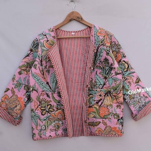 May include: A pink and green floral print quilted jacket with a striped lining. The jacket has a long, open front and long sleeves.