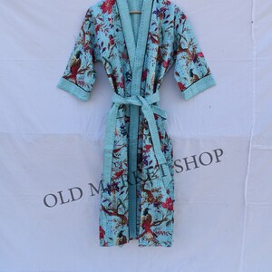 May include: A light blue robe with a floral print featuring birds and flowers. The robe has a black trim and a matching tie belt.