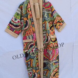 May include: A long, colorful, patterned robe with a tie belt. The robe is made of a soft, quilted fabric and has a relaxed fit. The fabric features a variety of colors and patterns, including paisley, floral, and geometric designs. The robe is perfect for lounging around the house or for adding a touch of bohemian style to your wardrobe.