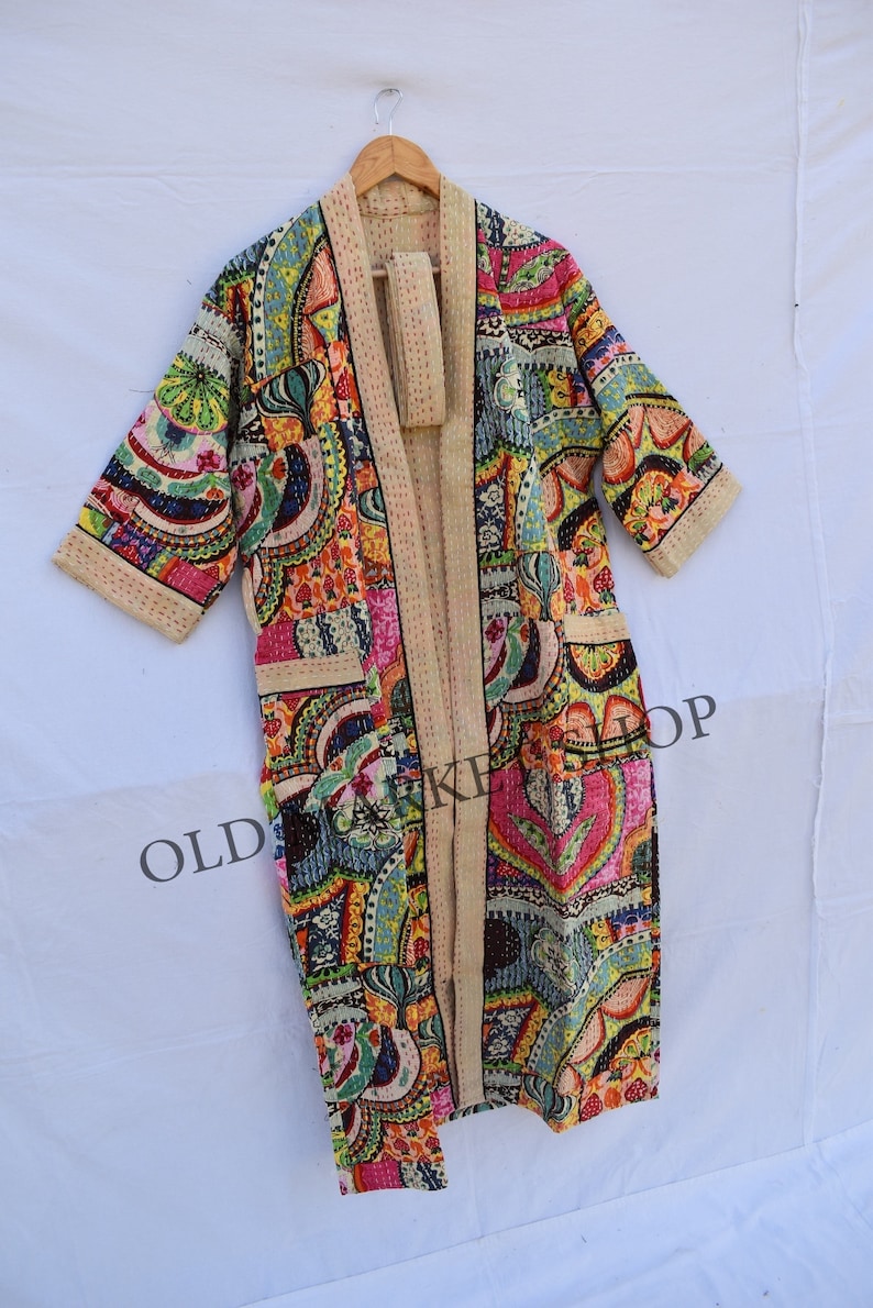 May include: A long, colorful, patterned robe with a tie belt. The robe is made of a soft, quilted fabric and has a relaxed fit. The fabric features a variety of colors and patterns, including paisley, floral, and geometric designs. The robe is perfect for lounging around the house or for adding a touch of bohemian style to your wardrobe.