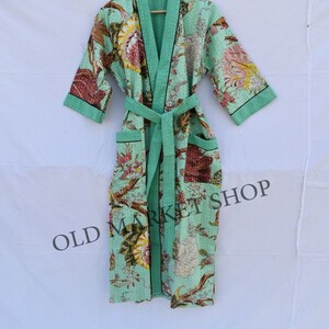 May include: A mint green floral patterned robe with a black trim and a matching sash. The robe has two pockets and is made of a soft, comfortable fabric. OLD MARKET SHOP is printed on the bottom of the robe.