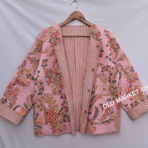 May include: A pink floral quilted jacket with a striped lining and a button closure. The jacket has two pockets and a relaxed fit.