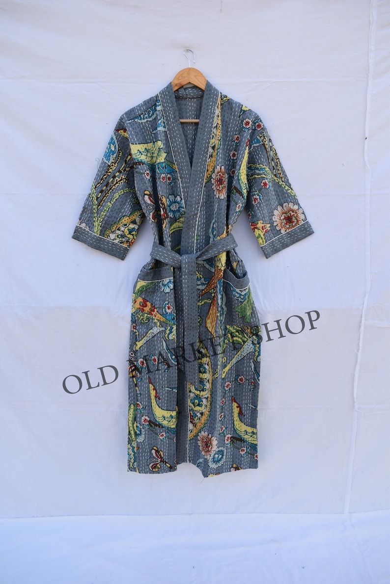 May include: A gray cotton robe with a floral print and a tie belt. The robe has a quilted design and is made in India.