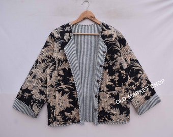 Könnte beinhalten: Eine reversible Jacke in Schwarz und Creme mit einem Blumendruck auf der einen Seite und einem gestreiften Muster auf der anderen. Die Jacke hat einen Knopfverschluss und eine Tasche auf der Vorderseite. "Old Market Shop" ist auf der Jacke aufgedruckt.