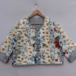 May include: White quilted jacket with a floral print and blue trim. The jacket has a button closure and two pockets.