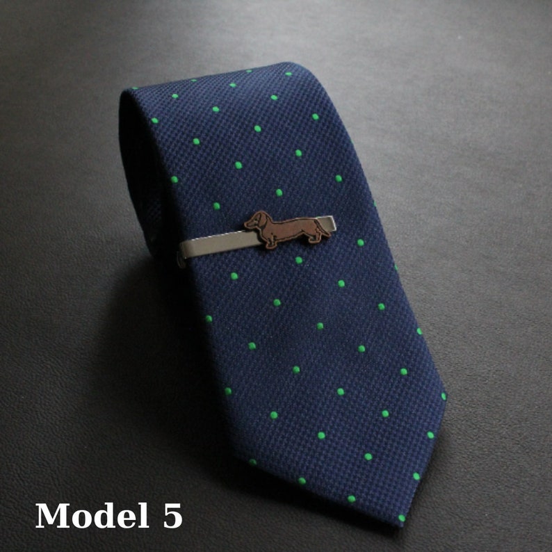 May include: Navy blue tie with a green polka dot pattern and a dachshund tie clip. The tie clip is silver with a brown dachshund silhouette. The text "Model 5" is at the bottom of the image.