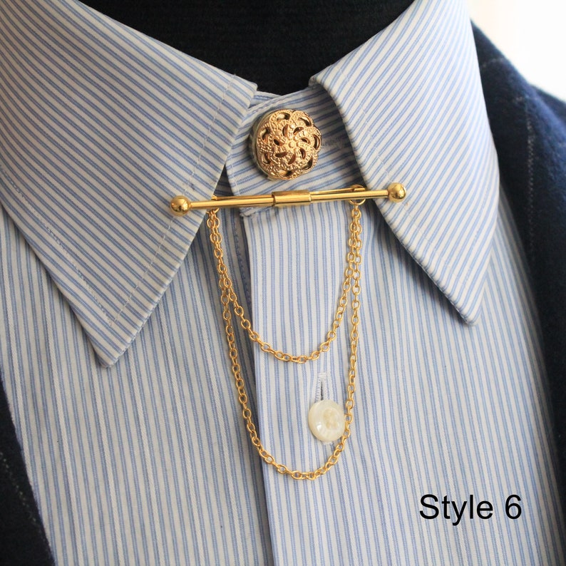Pode incluir: Alfinete de colarinho dourado com bot&atilde;o decorativo e detalhe de corrente. O alfinete est&aacute; preso a uma camisa listrada azul clara e branca. O texto "Style 6" &eacute; vis&iacute;vel no canto inferior direito.