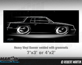 May include: Black and white line art illustration of a car on a black background. The text "Heavy Vinyl Banner welded with grommets 7'x3' or 4'x2'" is below the image. The text "ROBERT MARTIN 2016" is in the bottom right corner.