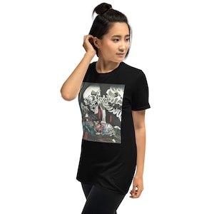 May include: Black t-shirt featuring a detailed graphic print. The print depicts a skeletal figure with a large skull, and other figures in colorful clothing. The artwork has a traditional Japanese aesthetic.