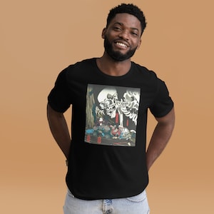 May include: Black t-shirt featuring a graphic print of a skeleton and figures in a traditional Japanese art style. The artwork includes a large skull and figures in colorful clothing. The t-shirt is made of a soft material.