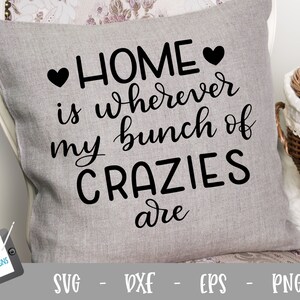May include: A grey throw pillow with black text that reads "HOME is wherever my bunch of CRAZIES are" with two black hearts on either side of the word "HOME".
