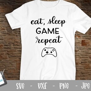 May include: White t-shirt with black text that reads "eat, sleep GAME repeat" and a black video game controller graphic.