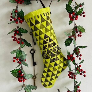 Calcetín navideño verde de retazos, decoración navideña hecha a mano con adornos metálicos vintage.