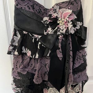 Lacey ruffled romantic crossbody bag with fabric flower and rhinestone brooch embellishment.