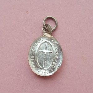May include: Silver oval charm with a cross and the text "AVE GRACIEUSE" and "1204".
