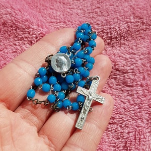 Religious antique French catholic rosary with light blue glass beads and a silver plated aluminium crucifix with Jesus Christ.