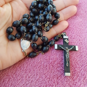 Religious antique French catholic rosary with black wooden beads and a silver plated crucifix with Jesus Christ.