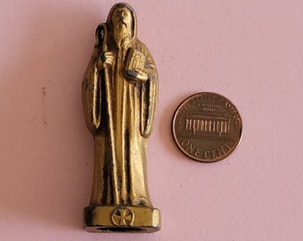 以下が含まれることがあります： 本と杖を持った聖人の金色の金属製フィギュア。フィギュアはアメリカの1セント硬貨と同じくらいの大きさです。