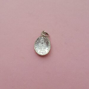 May include: Silver charm with a detailed design of a building with a dome and a cross on top. The charm is oval shaped and has a loop at the top for attaching to a chain or bracelet.