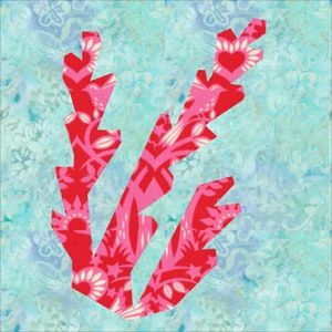 May include: A pink and red fabric applique of three stylized leaves with a white floral pattern. The leaves are on a light blue background.