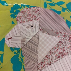 May include: A patchwork quilt block featuring a geometric design with various shades of brown, pink, and white fabrics. The block is made up of different patterns, including stripes, plaid, and floral prints. The quilt block is set against a background of green and turquoise fabric with a floral pattern.