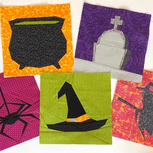 May include: Five fabric squares with Halloween-themed appliques. The squares are orange with a black cauldron, purple with a gray tombstone, pink with a black spider, green with a black witch's hat, and orange with a black witch on a broomstick.