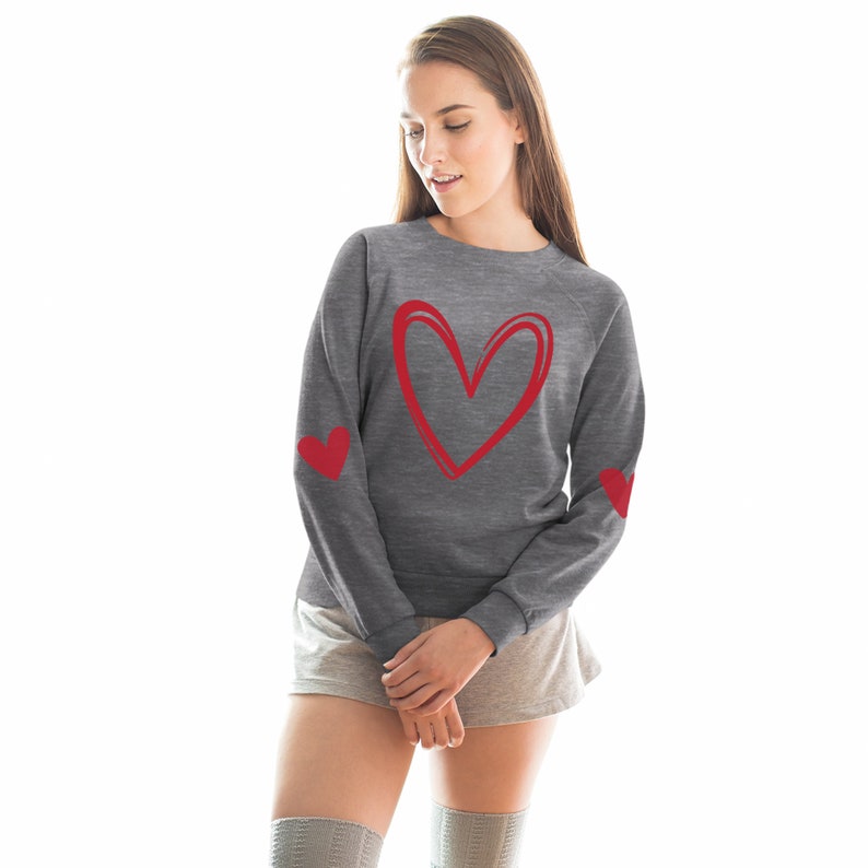 May include: Gray sweatshirt with a red heart design on the front and red hearts on the elbows.