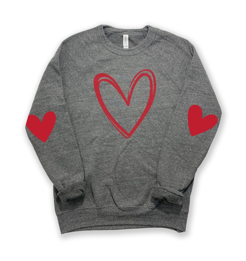 May include: A gray sweatshirt with a red heart design on the front and red hearts on the elbows.