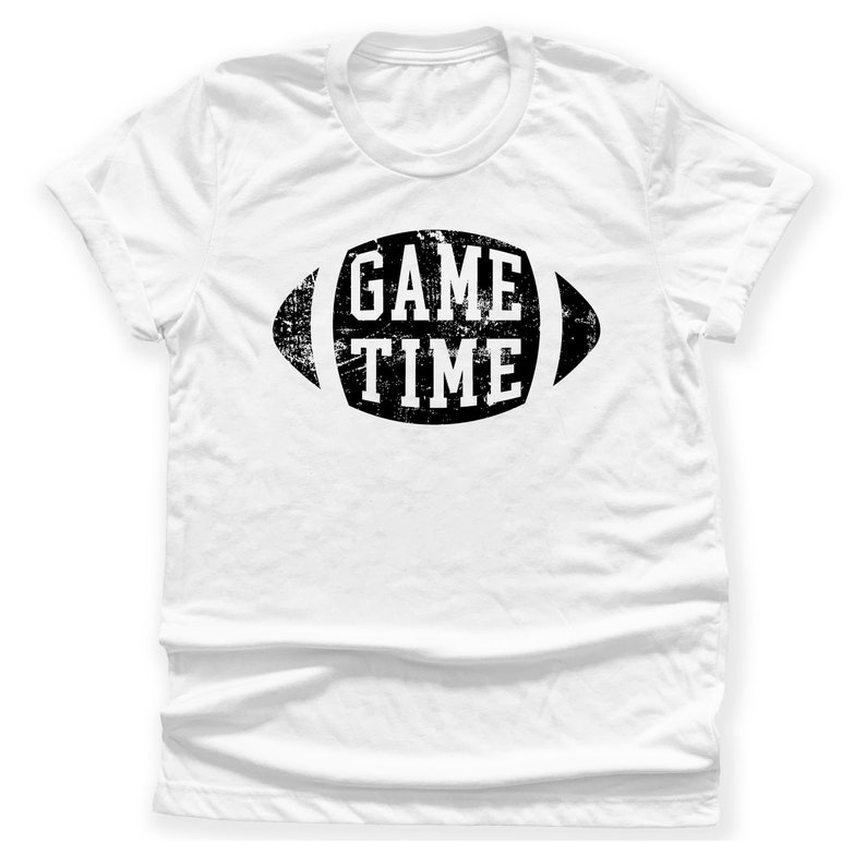 Puede incluir: Camiseta blanca con un gr&aacute;fico negro desgastado de un bal&oacute;n de f&uacute;tbol con el texto "GAME TIME" en su interior.
