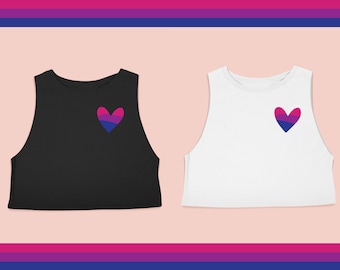 May include: Two sleeveless crop tops with a bisexual pride heart on the front. One top is black and the other is white.