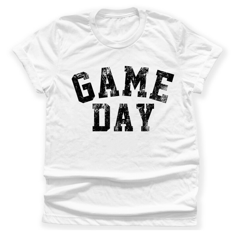 May include: White t-shirt with black text that reads "GAME DAY" in a distressed font.