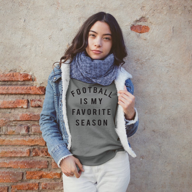 Puede incluir: Una camiseta gris con el texto "FOOTBALL IS MY FAVORITE SEASON" impreso en ella.