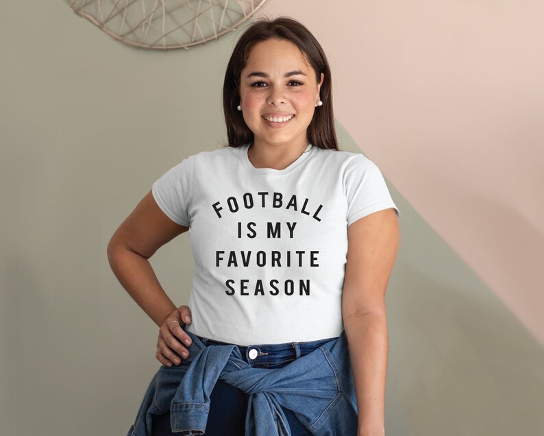 Puede incluir: Camiseta blanca con texto negro que dice "Football is my favorite season".