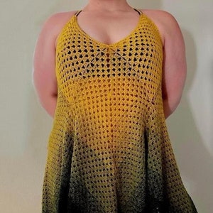 Puede incluir: Un top de crochet amarillo y negro con estilo de cuello halter. El top está hecho con una puntada suelta y abierta y tiene un patrón de degradado.
