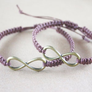 May include: Two matching bracelets with a woven, mauve-colored band and a bronze-colored infinity symbol. The bracelets are adjustable with a sliding knot closure. The bracelets are a symbol of everlasting love and friendship.