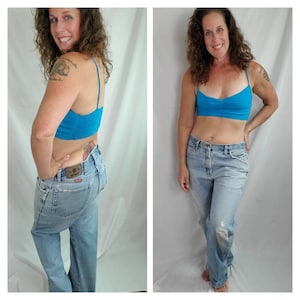 K&ouml;nnte beinhalten: Eine Frau tr&auml;gt eine hellblaue Jeans mit einem Destroyed-Detail am linken Bein und ein t&uuml;rkisfarbenes Tanktop.