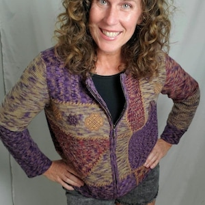 Könnte beinhalten: Ein gepunkteter, gezippter Pullover in Lila, Braun und Beige mit geometrischem Muster.