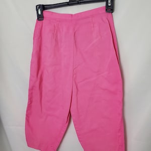 May include: Pink capri pants with a straight leg and a simple design.