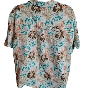 May include: Short-sleeved button-down shirt with a tropical leaf pattern in shades of brown, teal, and white. The shirt has a classic collar and a relaxed fit, suitable for casual wear.