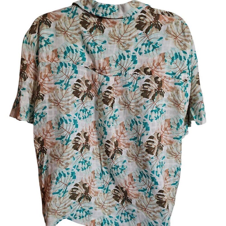 May include: Short-sleeved button-down shirt with a tropical leaf pattern in shades of brown, teal, and white. The shirt has a classic collar and a relaxed fit, suitable for casual wear.