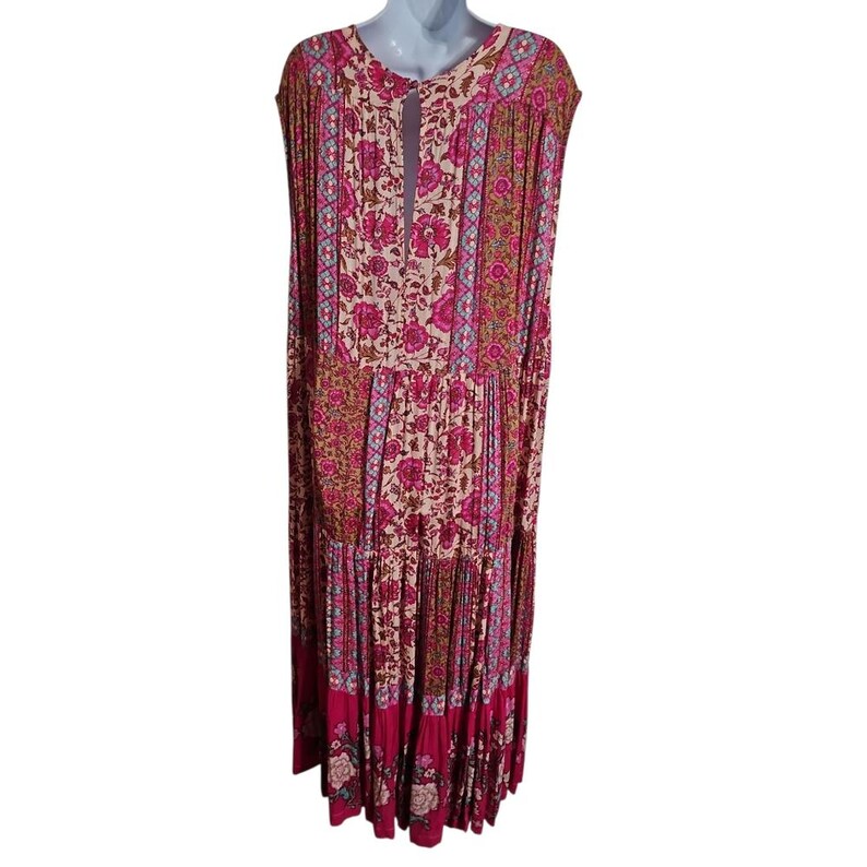 May include: A long, flowing dress with a floral pattern in shades of pink, cream, and teal. The dress features a keyhole neckline and a tiered skirt. The sleeves are short and cap-like. The dress is made of a lightweight fabric.