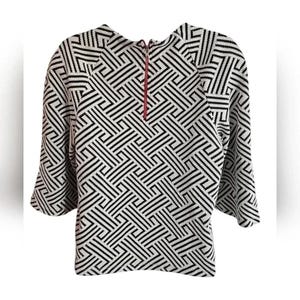 May include: A black and white geometric patterned top with three-quarter sleeves. The top has a high neckline and a red zipper detail. The pattern is a repeating design of black lines on a white background.